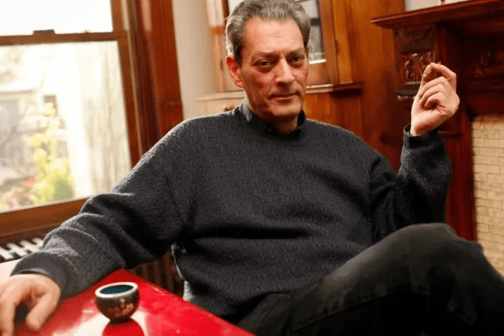 Figura solitaria frente a una ventana con lluvia, evocando la frase de Paul Auster sobre la soledad y el amor.